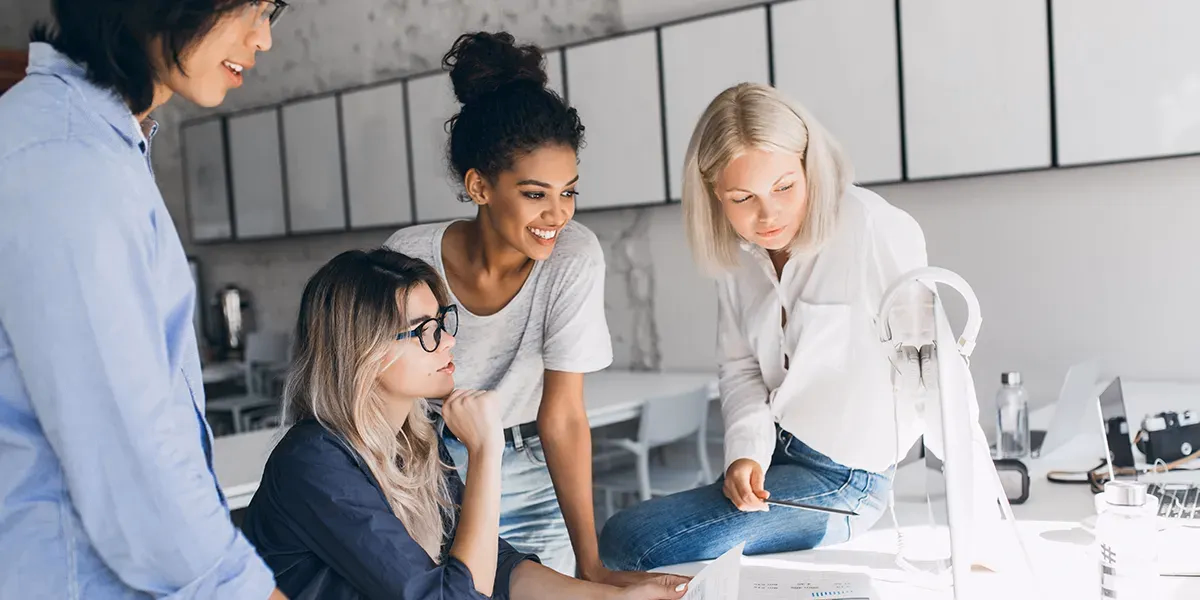 conjunto de mujeres trabajando cooperativamente en un ordenador