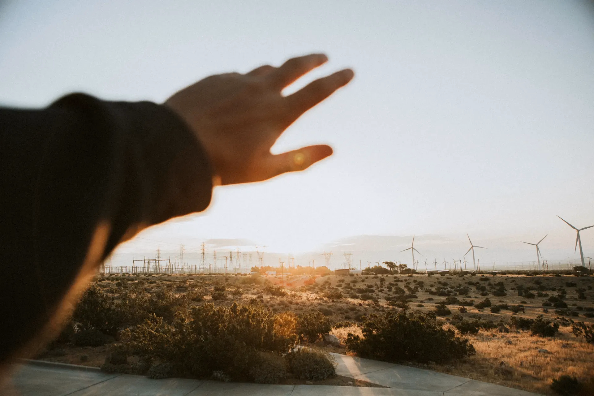 Paisaje con turbinas eólicas al atardecer, simbolizando la transición hacia energías renovables con seguridad energética y la lucha contra el cambio climático