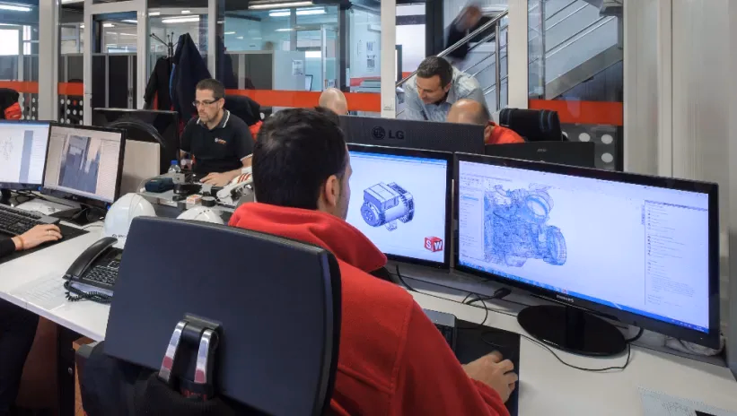 Ingenieros trabajando en el diseño de componentes en 3D, aplicando tecnología de fabricación aditiva