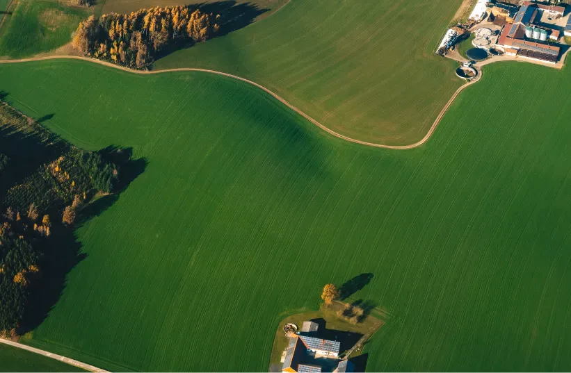 Vista aérea de una zona rural con campos amplios y edificaciones dispersas.